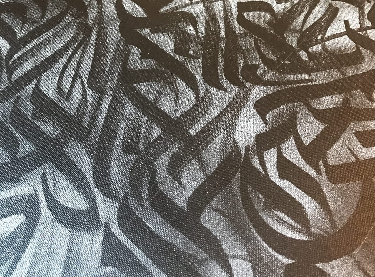 A thin layer of spraypaint on top of a calligraphy composition