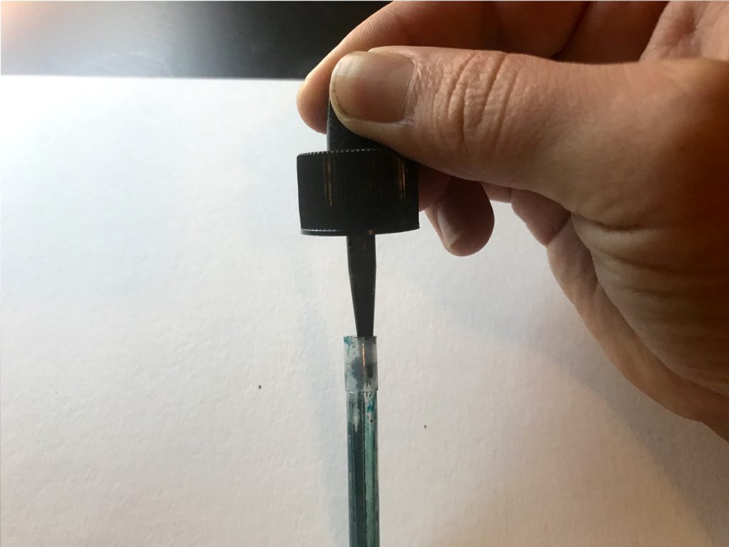Squeeze ink past the stopper to fill